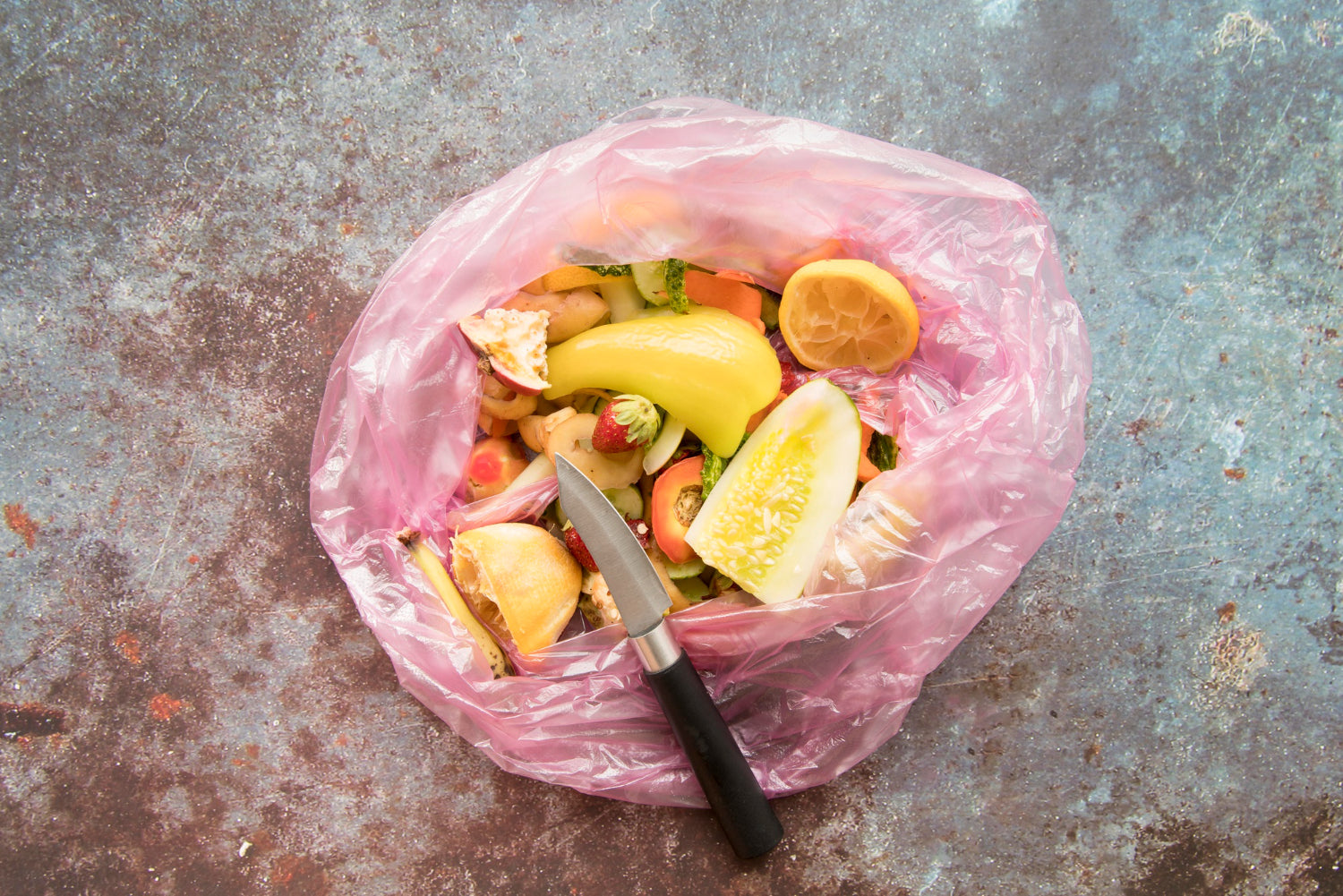 Compostable trash bag with wet food waste, showing how compostable bags break down