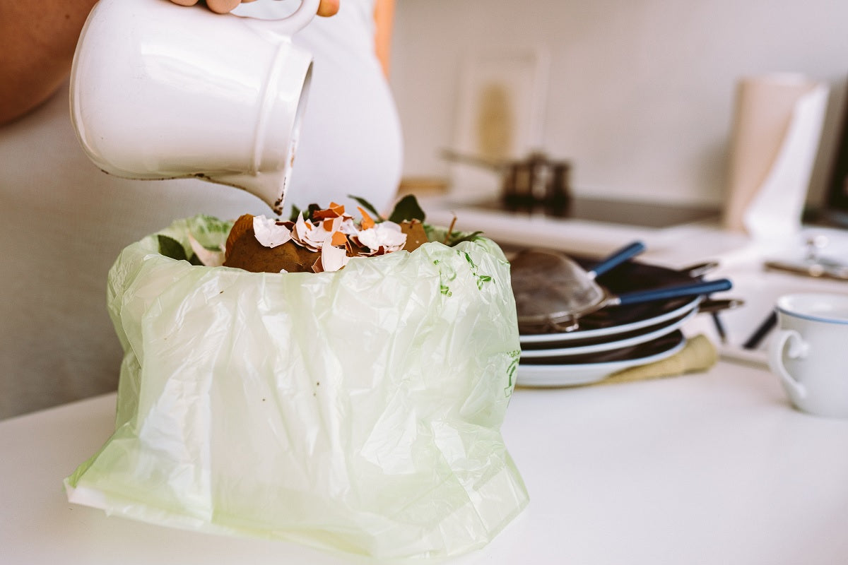 Compostable bag in a kitchen bin, eco-friendly kitchen cleaning hacks for a greener home
