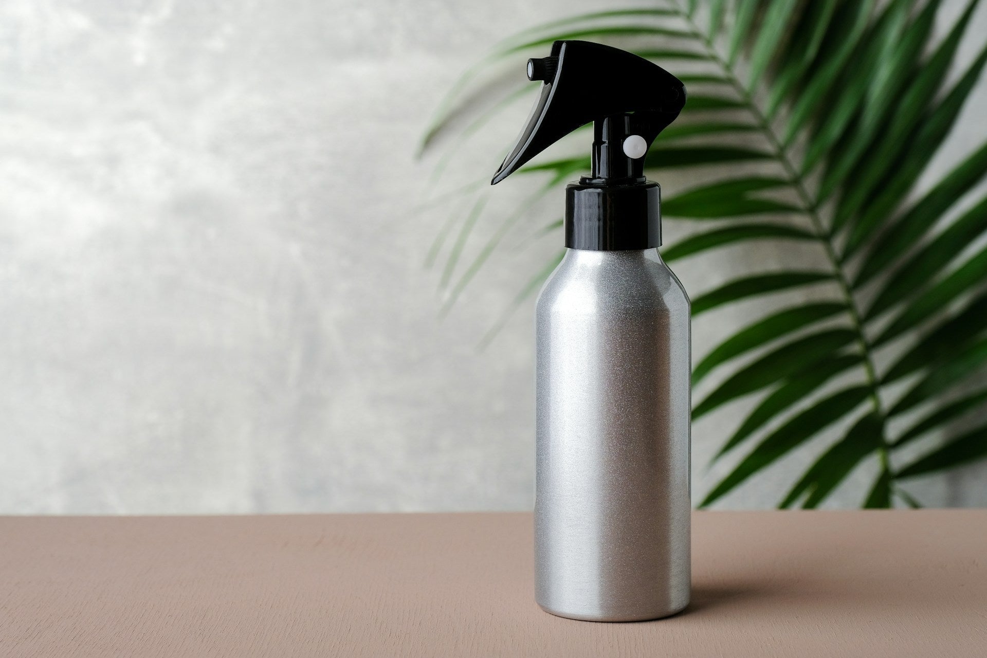 Refillable cleaner bottles kept organized on a shelf for an easy plastic-free cleaning routine