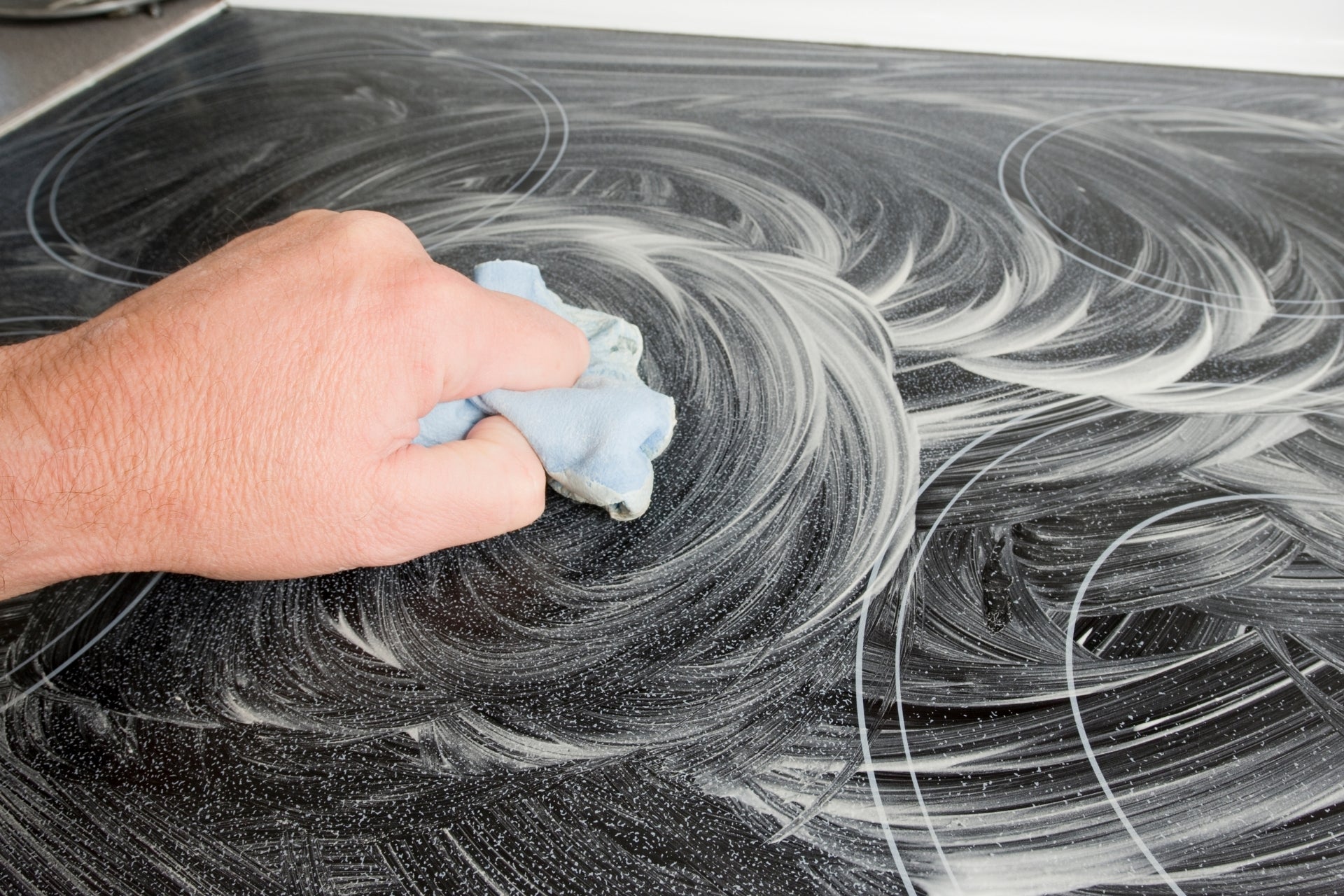 Cloth wiping a black glass ceramic stove top clean