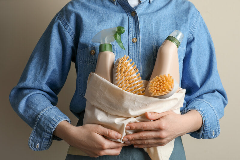 Person holding eco-friendly cleaning products, a beginner's guide to a greener home