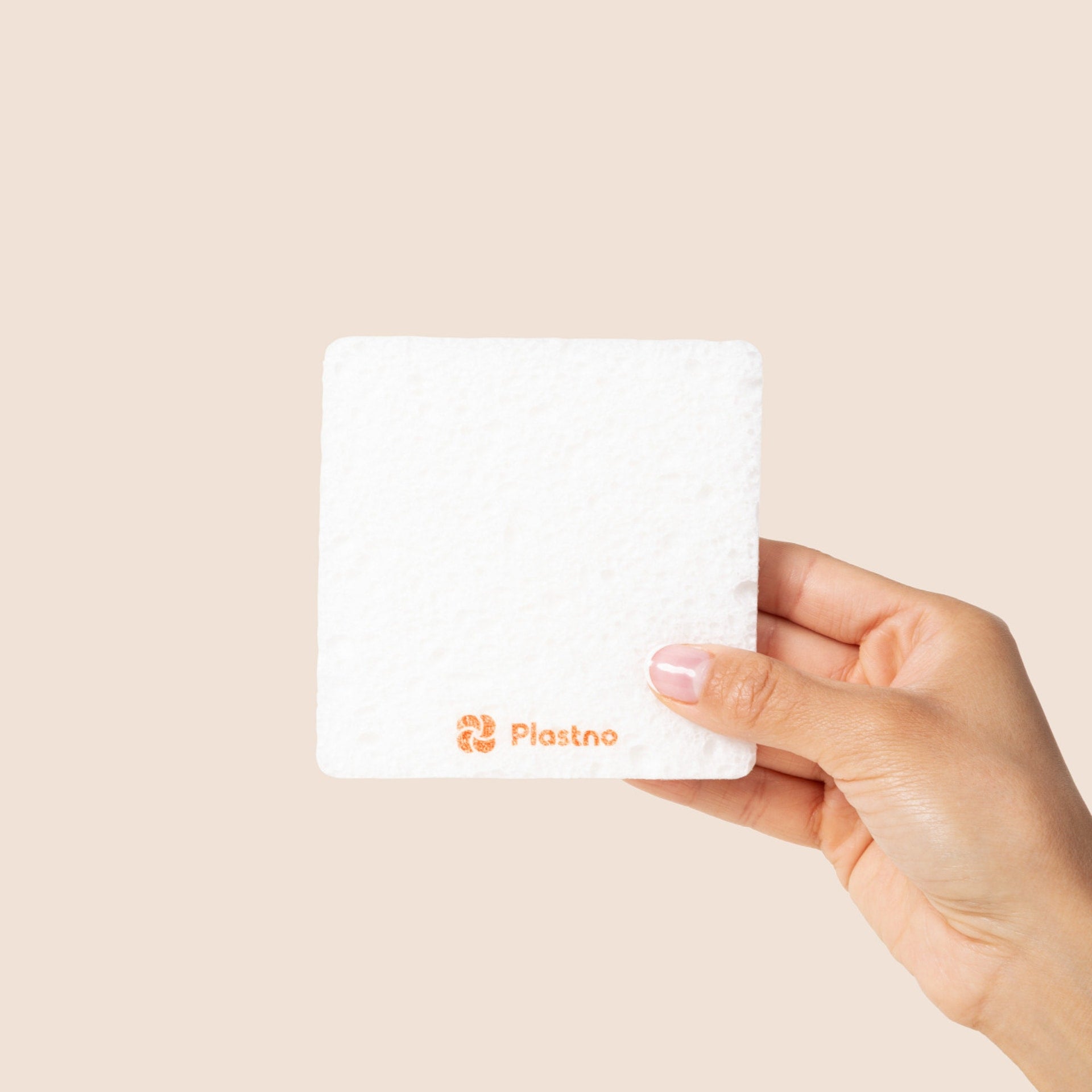 Plastno Soak Sponge: hand holding a single 3.75 inch square cellulose dish sponge, expanded