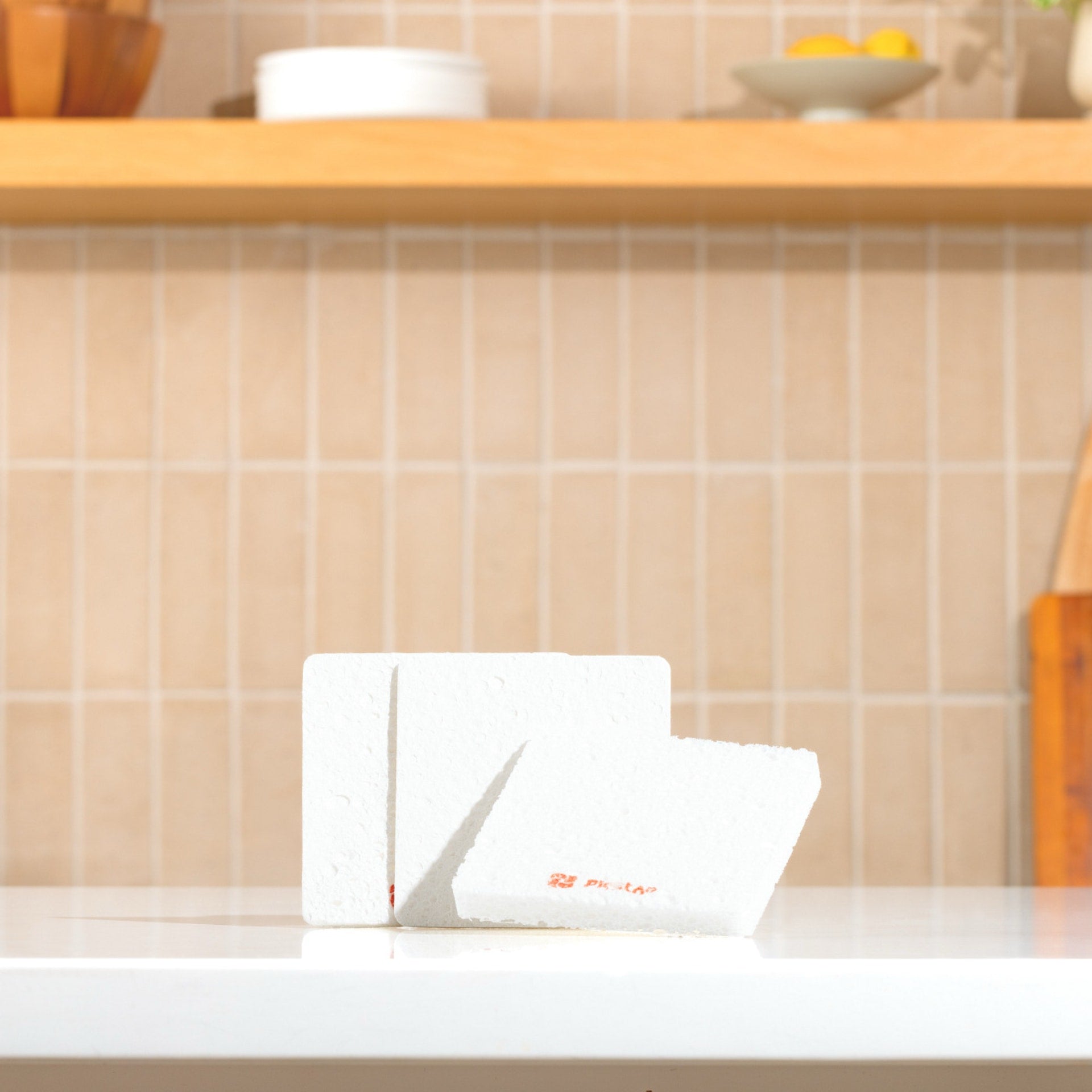 Plastno Soak Sponge: two cellulose dish sponges standing flat on a kitchen counter before they expand in water