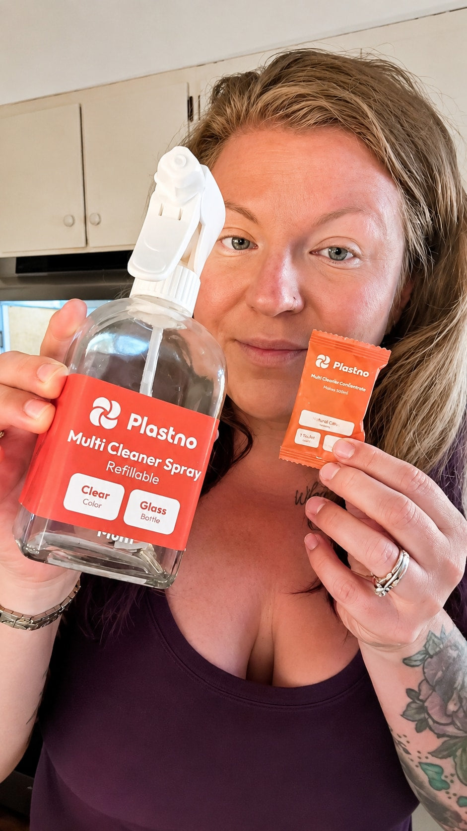 Creator holding the Plastno refillable Multi Cleaner Spray glass bottle in one hand and a Multi Cleaner Concentrate tablet packet in the other