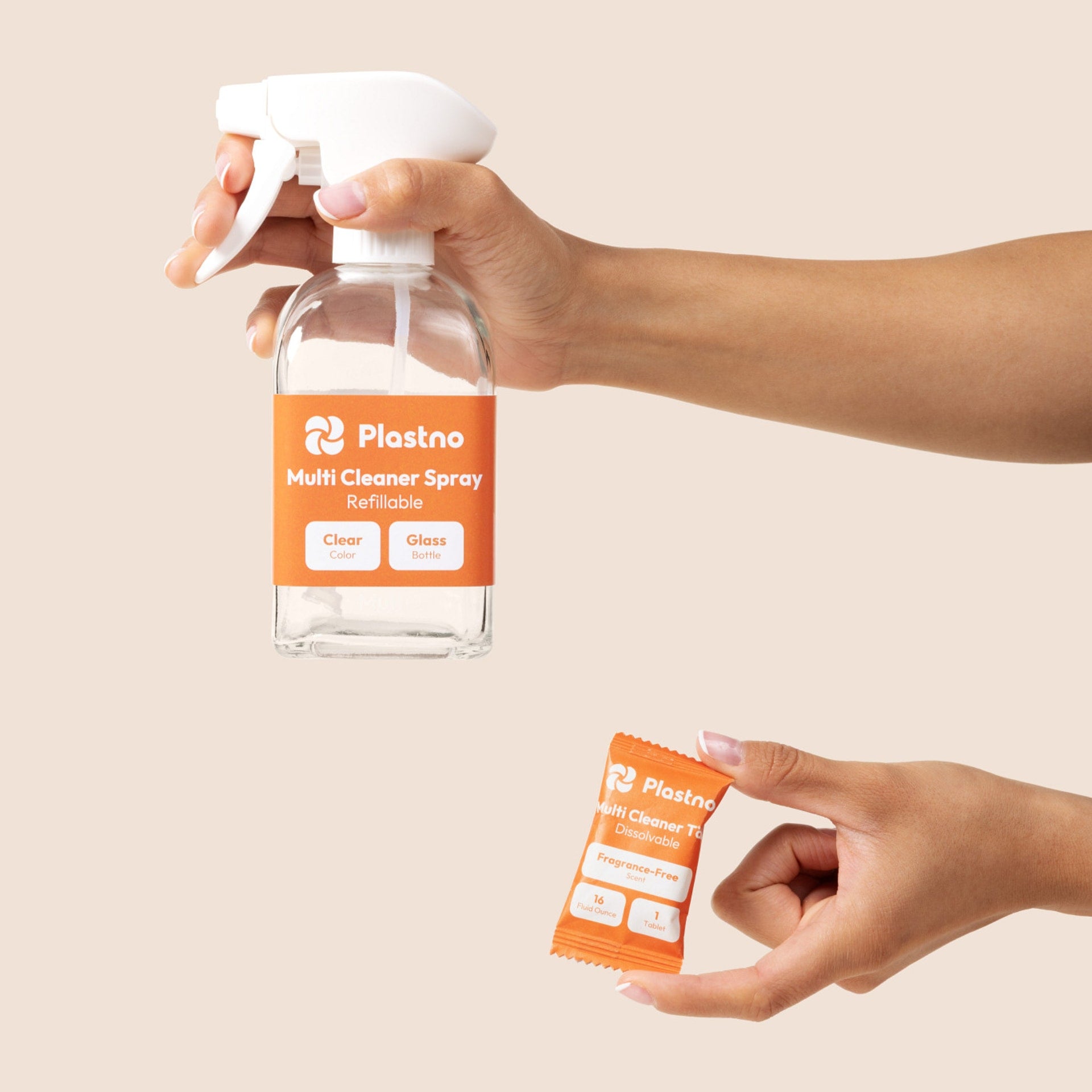 Hands holding the Plastno refillable glass Multi Cleaner Spray bottle and a fragrance-free multi cleaner tablet packet on a beige background