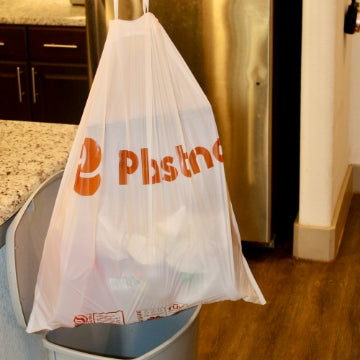 Holding Plastno compostable trash Bag full of trash