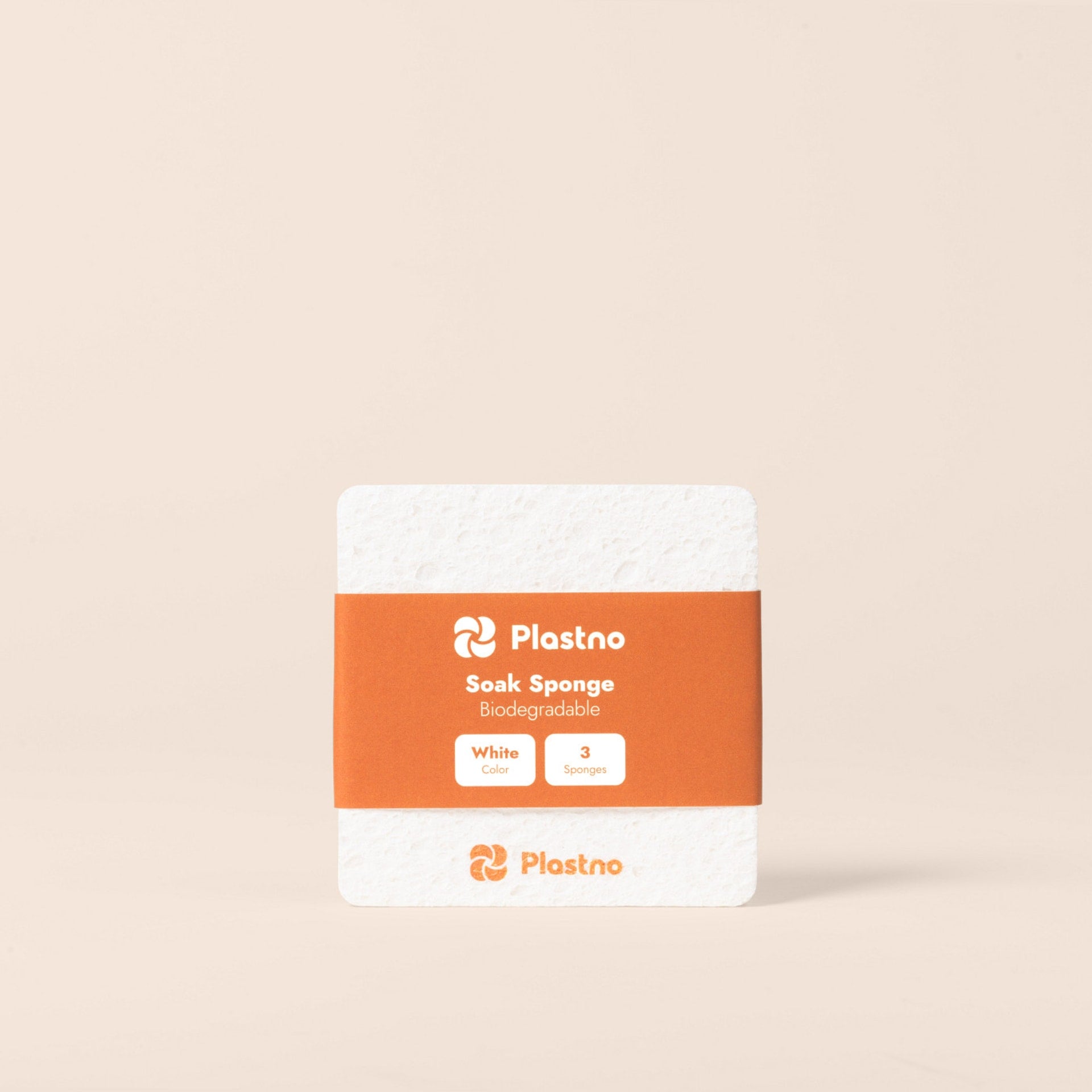 Plastno Soak Sponge: biodegradable cellulose sponge 3-pack in white with an orange paper band on a beige background