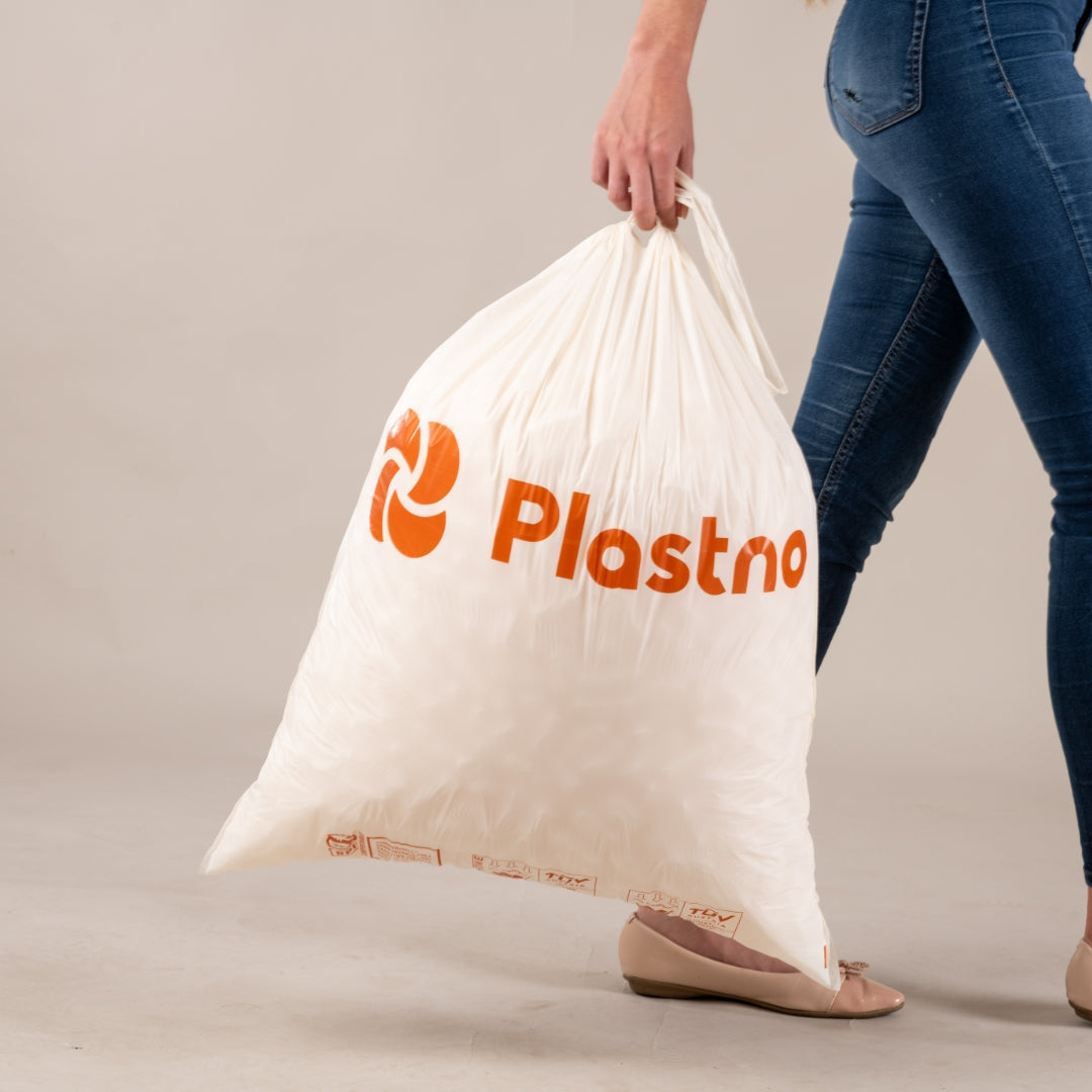 Taking out the trash in a Plastno compostable trash bag
